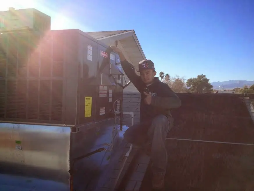 HVAC technician performing Air Duct Cleaning on a rooftop unit in Fairwood